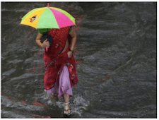 Indian woman walking through water - Flooding in India  - dpa