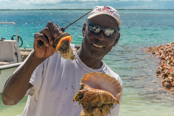 Bahamian with conch mollusk in hand