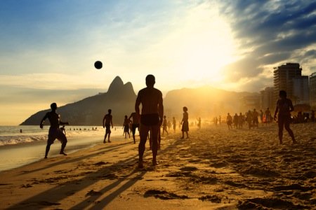Kids playing soccer on beach - sugar loaf mountain in background