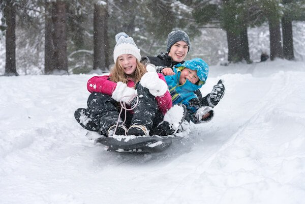 Kids tobogganing in snow