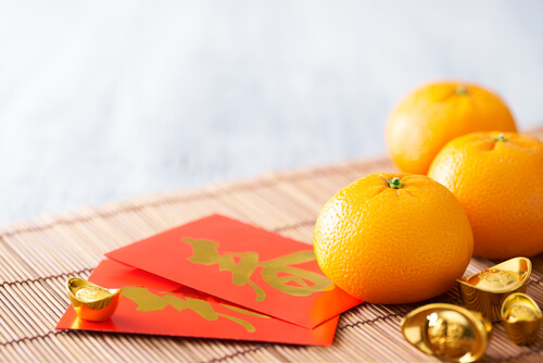 Chinese New Year red packets and oranges - image: shurtterstock.com Chinese New Year red packets and oranges - image: shurtterstock.com